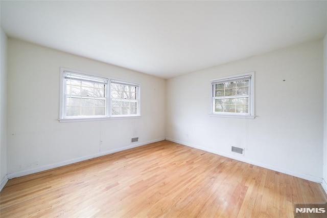 unfurnished room with light hardwood / wood-style floors and a wealth of natural light