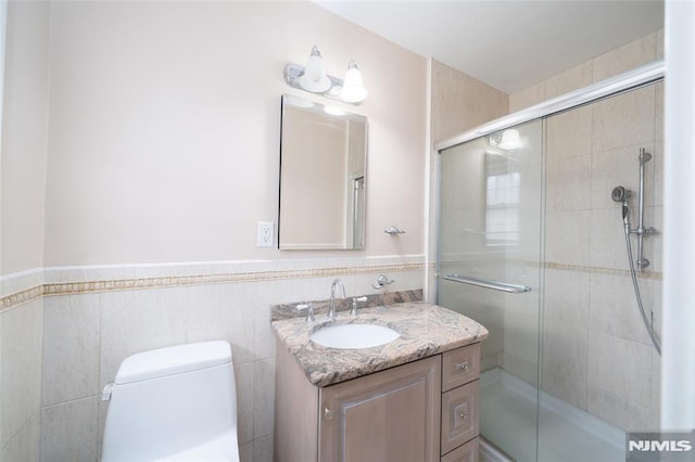 bathroom with toilet, a shower with shower door, and vanity