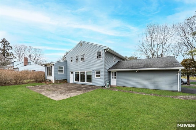 back of property with a lawn and a patio