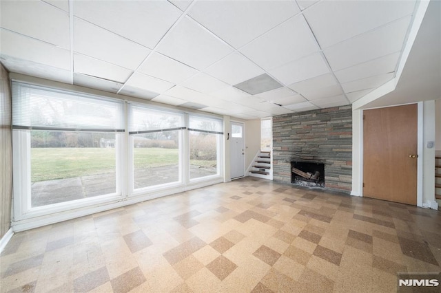 unfurnished living room featuring carpet and a drop ceiling