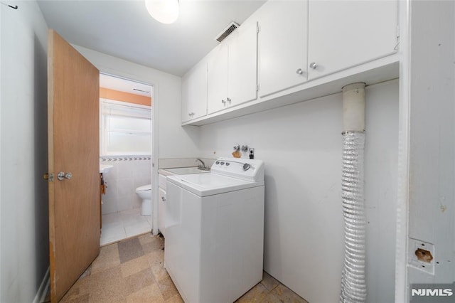 laundry room with cabinets, tile walls, and washer / clothes dryer