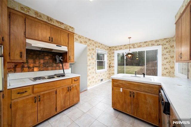 kitchen with stainless steel dishwasher, sink, white stovetop, hanging light fixtures, and light tile patterned floors