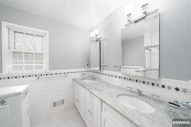 bathroom featuring lofted ceiling, vanity, tile walls, and tile patterned floors