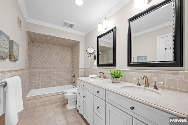 bathroom with toilet, tiled bath, tile patterned flooring, ornamental molding, and vanity