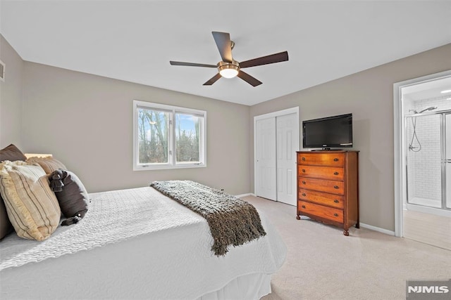 bedroom featuring ceiling fan, ensuite bath, a closet, and light carpet