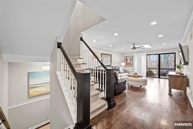 stairs featuring ceiling fan, hardwood / wood-style floors, and crown molding