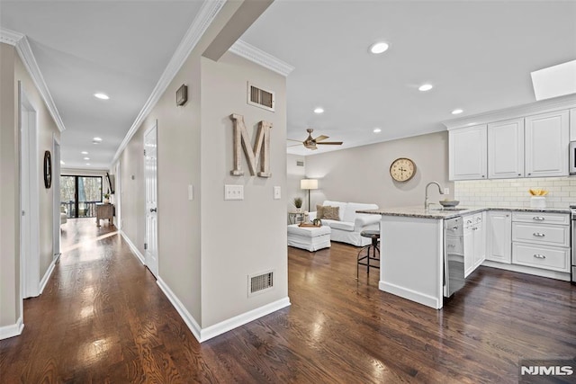 kitchen featuring sink, white cabinets, kitchen peninsula, and a breakfast bar area