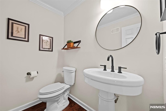 bathroom featuring toilet, crown molding, and hardwood / wood-style floors