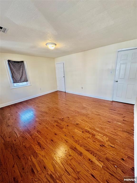 empty room featuring hardwood / wood-style floors and a textured ceiling