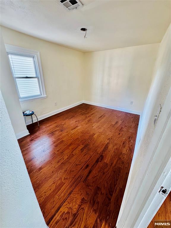 empty room with dark hardwood / wood-style flooring