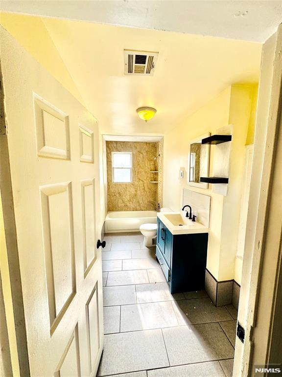 bathroom with tile patterned flooring, vanity, and toilet