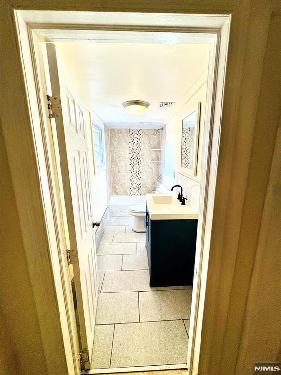 bathroom featuring toilet, vanity, and tile patterned floors