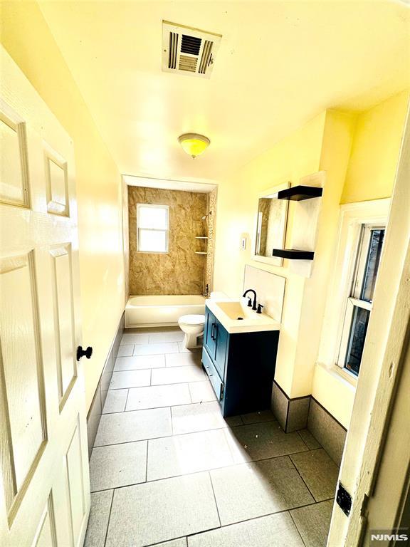 full bathroom with tile patterned floors, shower / tub combination, vanity, and toilet