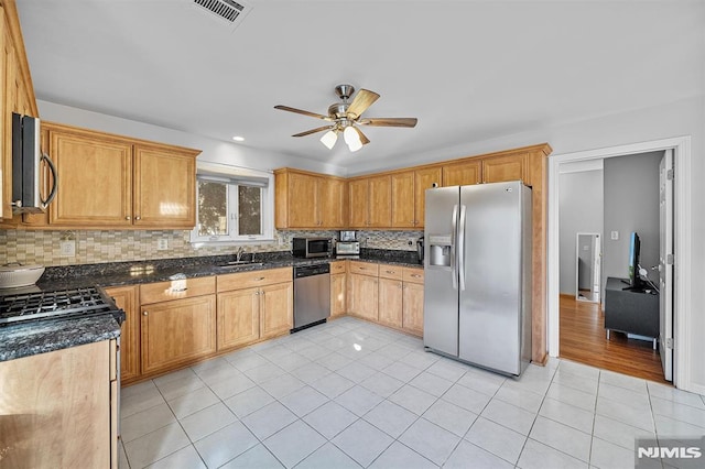 kitchen with ceiling fan, sink, stainless steel appliances, tasteful backsplash, and light tile patterned floors