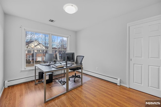 office with light wood-type flooring and baseboard heating