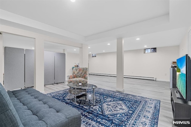 living room with a baseboard heating unit and light wood-type flooring