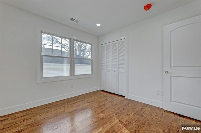 unfurnished bedroom featuring light wood-type flooring and a closet