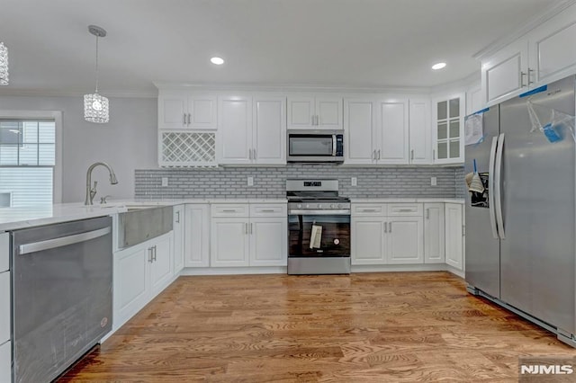 kitchen featuring appliances with stainless steel finishes, pendant lighting, and white cabinetry