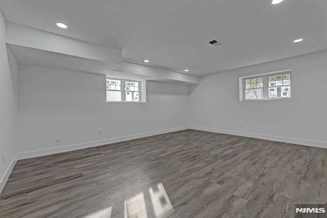 basement featuring dark hardwood / wood-style flooring and a wealth of natural light