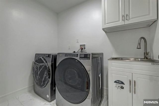 laundry room featuring sink, washing machine and dryer, and cabinets