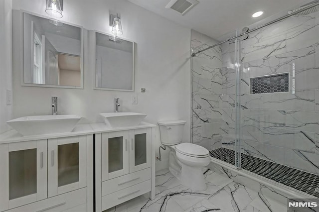 bathroom featuring vanity, a shower with shower door, and toilet