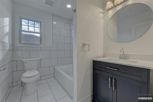 full bathroom with toilet, tile patterned flooring, tile walls, tiled shower / bath combo, and vanity