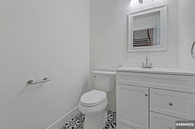 bathroom with tile patterned flooring, vanity, and toilet