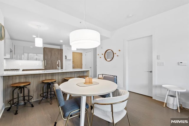 dining room with dark hardwood / wood-style flooring and sink