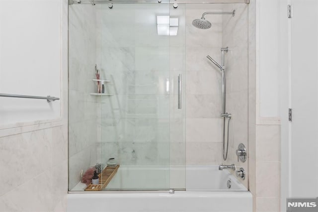 bathroom featuring bath / shower combo with glass door