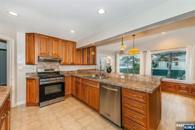 kitchen featuring appliances with stainless steel finishes, kitchen peninsula, hanging light fixtures, and sink