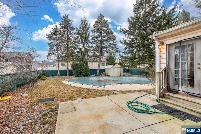 view of pool with a patio area and a shed