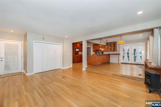 unfurnished living room featuring light wood-type flooring and french doors