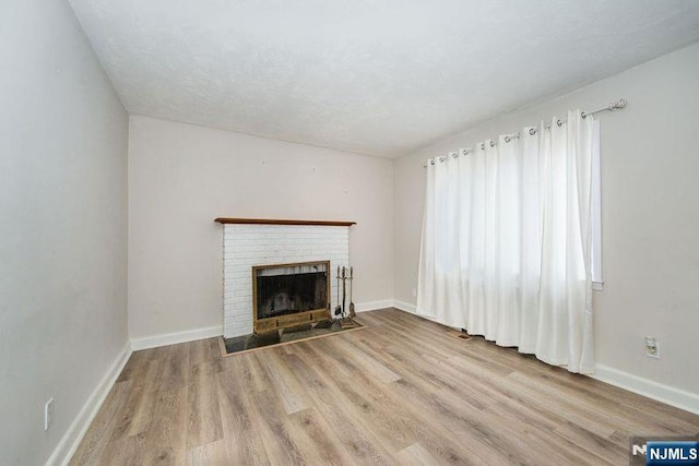 unfurnished living room featuring light hardwood / wood-style flooring and a fireplace