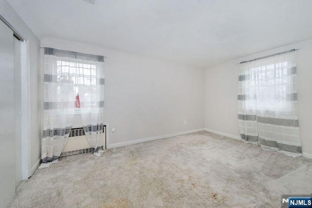 carpeted empty room featuring radiator