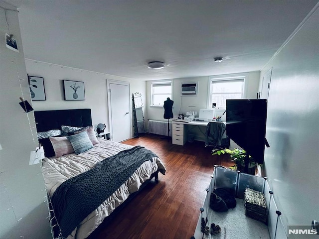 bedroom featuring a wall mounted air conditioner, dark hardwood / wood-style flooring, and radiator heating unit