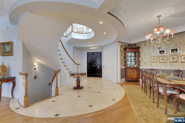 entryway featuring crown molding, a chandelier, and light hardwood / wood-style flooring