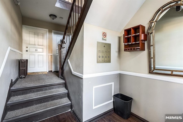 staircase featuring hardwood / wood-style floors and vaulted ceiling