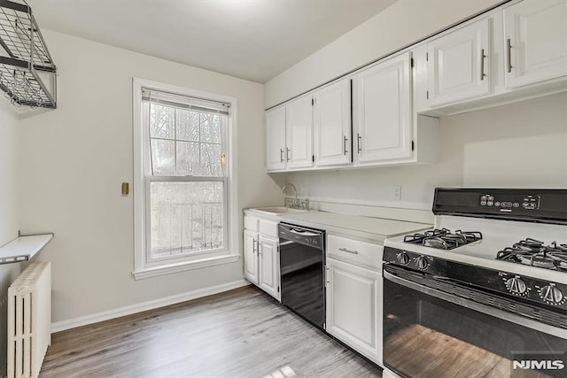 kitchen with radiator, white cabinetry, dishwasher, and range with gas cooktop