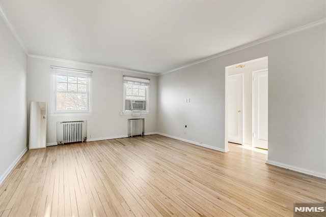 spare room featuring radiator, crown molding, cooling unit, and light wood-type flooring