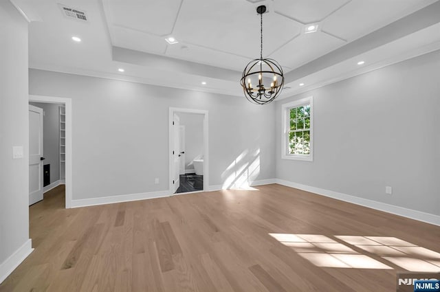 empty room featuring visible vents, a raised ceiling, baseboards, light wood-style flooring, and recessed lighting