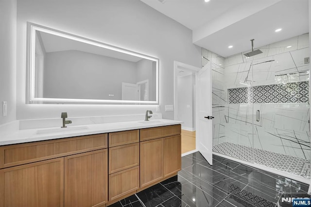 bathroom featuring double vanity, a sink, a marble finish shower, and recessed lighting