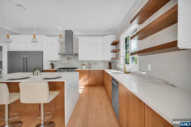 kitchen with wall chimney exhaust hood, appliances with stainless steel finishes, open shelves, and white cabinetry