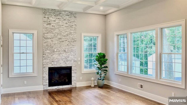 interior space with coffered ceiling, wood-type flooring, a fireplace, and beamed ceiling