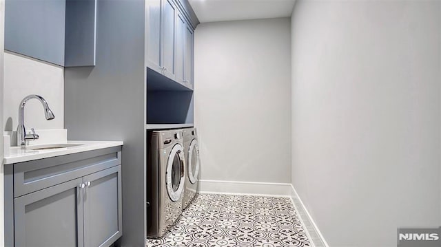 laundry room featuring sink, cabinets, washer and clothes dryer, and light tile patterned flooring