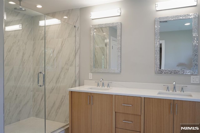 bathroom featuring vanity and a shower with shower door