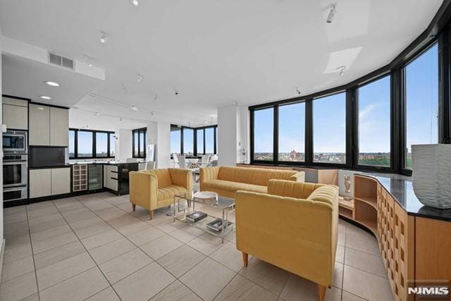 tiled living room featuring a wall of windows