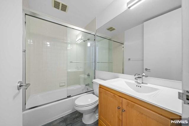 full bathroom with vanity, toilet, and bath / shower combo with glass door