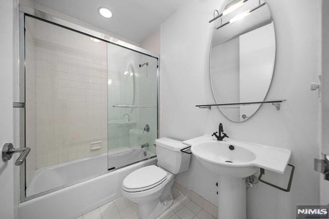 bathroom with tile patterned flooring, toilet, and enclosed tub / shower combo