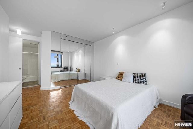 bedroom featuring a closet and parquet flooring