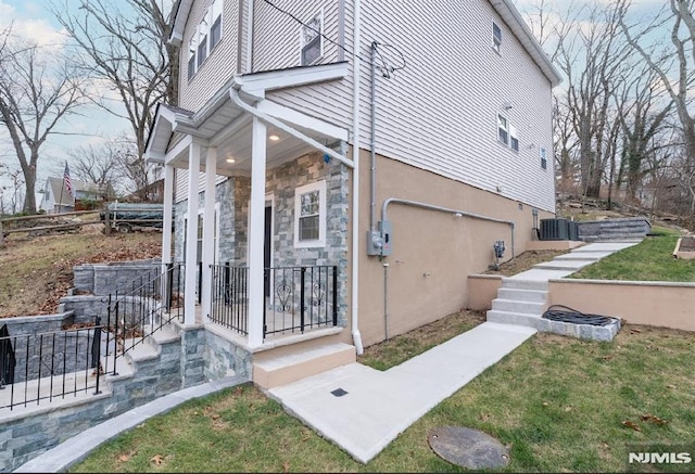 view of side of home with covered porch, central AC unit, and a garage